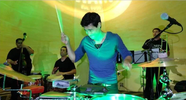 Salsa drummer performing in front of the Ball & Chain backdrop