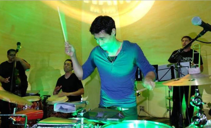 Salsa drummer performing in front of the Ball & Chain backdrop