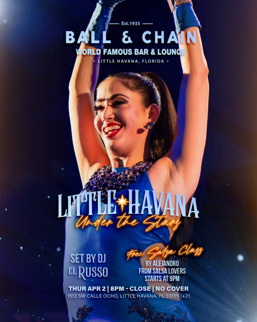 performer on stage with her arms over her head dancing